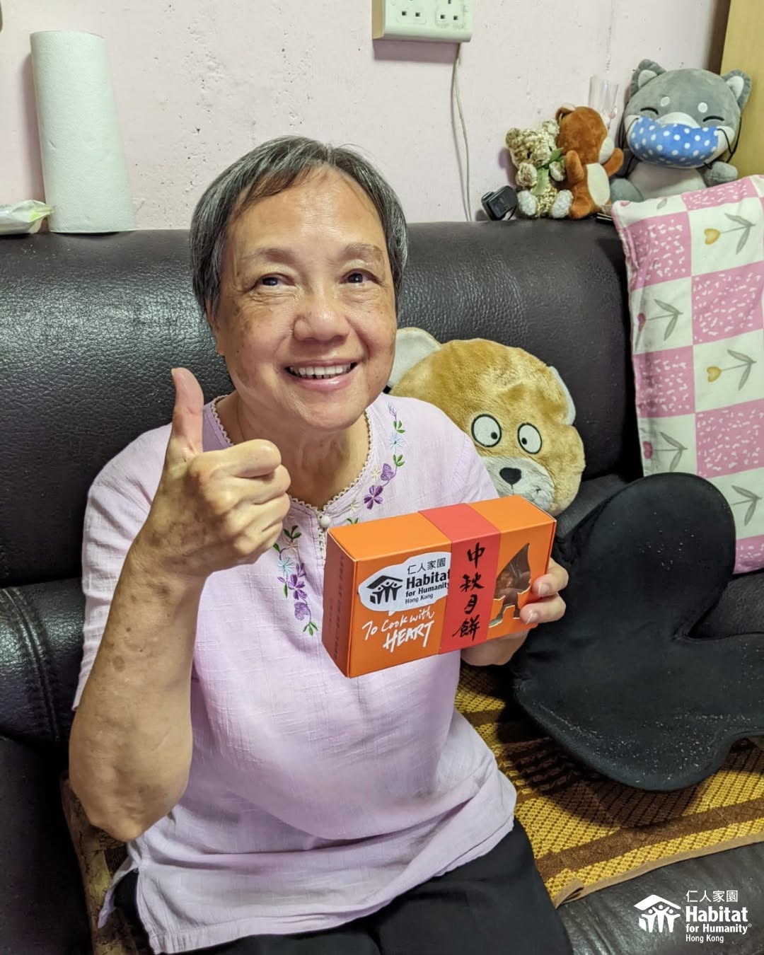 A resident giving a thumbs up in her renovated home