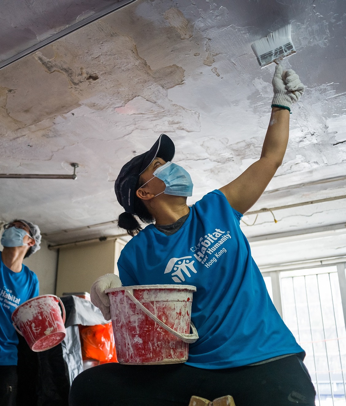 A Habitat volunteer repairing a ceiling in a Hong Kong flat