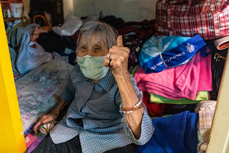 An elderly resident in her flat surrounded by accumulated belongings