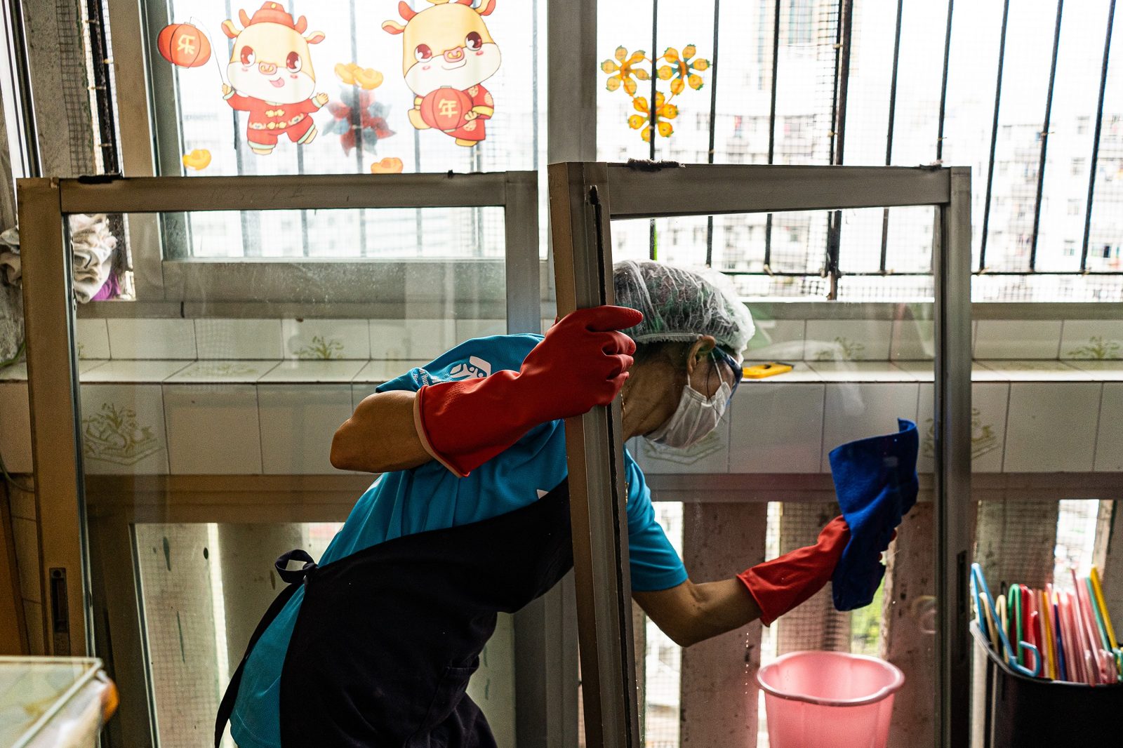 A cleaner wiping down windows during a deep clean of a flat