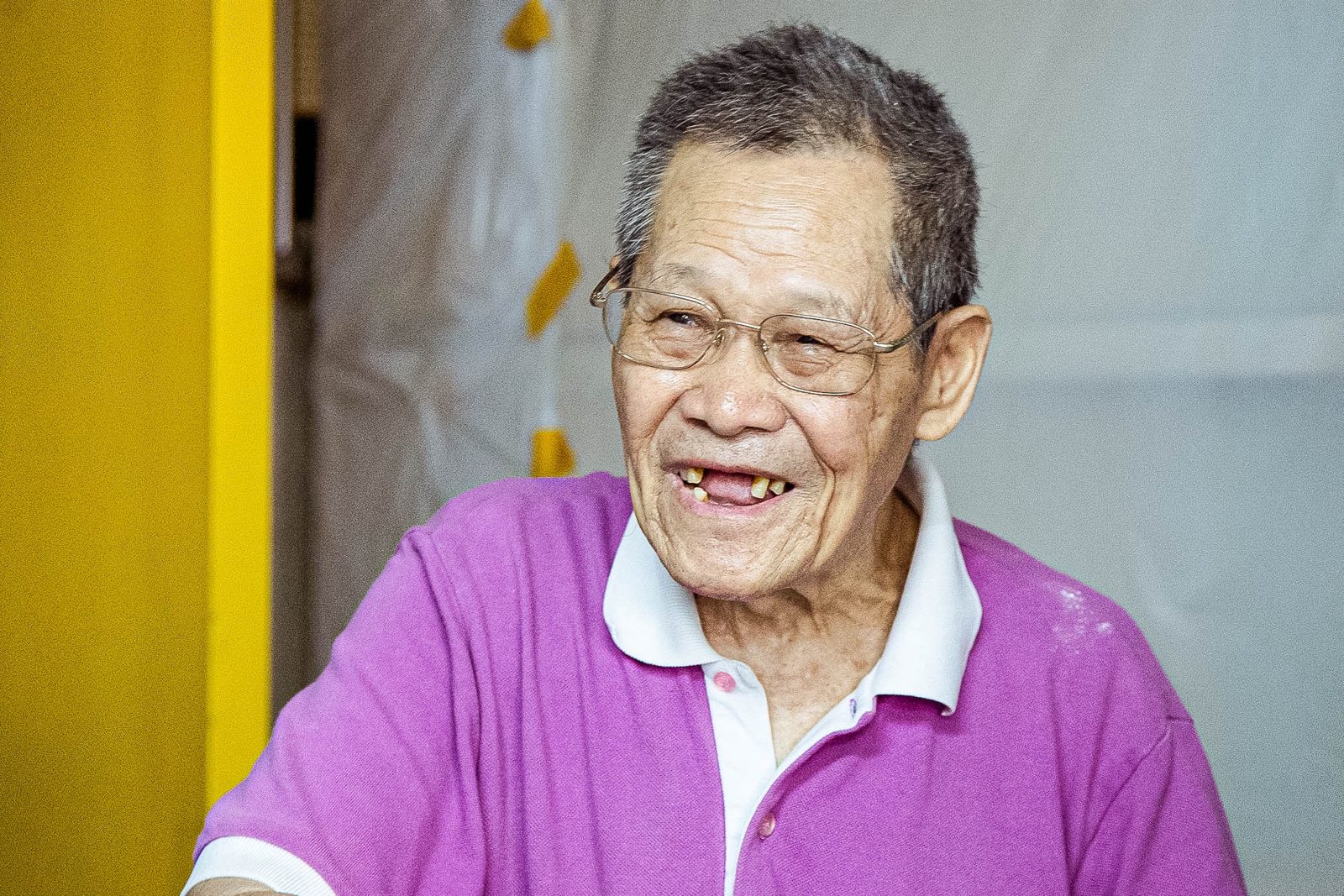 An elderly resident smiling in his home after improvements